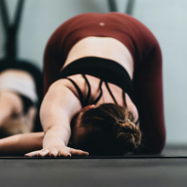A female on the floor doing a trunk twist in pilates